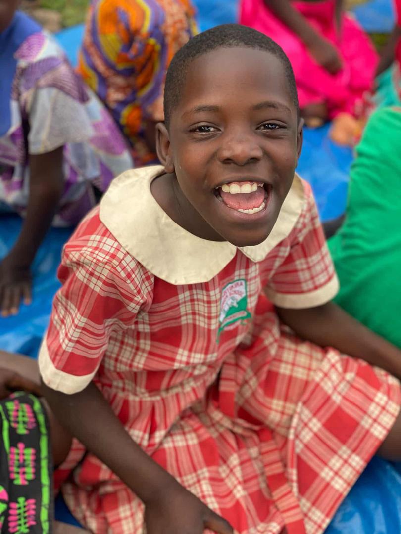 A smiling child in a school uniform